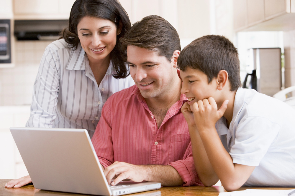 Contact page header image, family sitting around a laptop